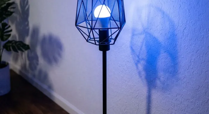 bombillas-inteligentes-rgb-cambio-color Primer plano de lámpara de diseño con bombilla inteligente RGB proyectando luz violeta para crear un ambiente relajante y moderno en el salón.